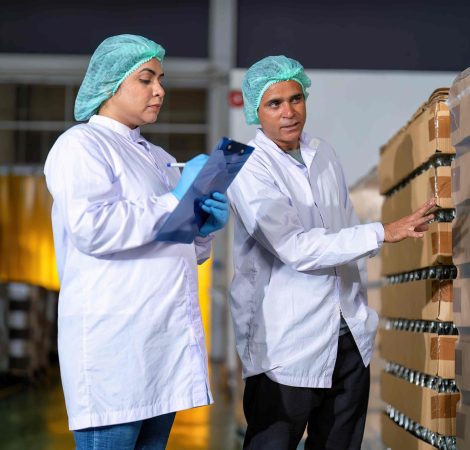 In warehouse quality control team checking drinking bottle stack on pallet before delivery